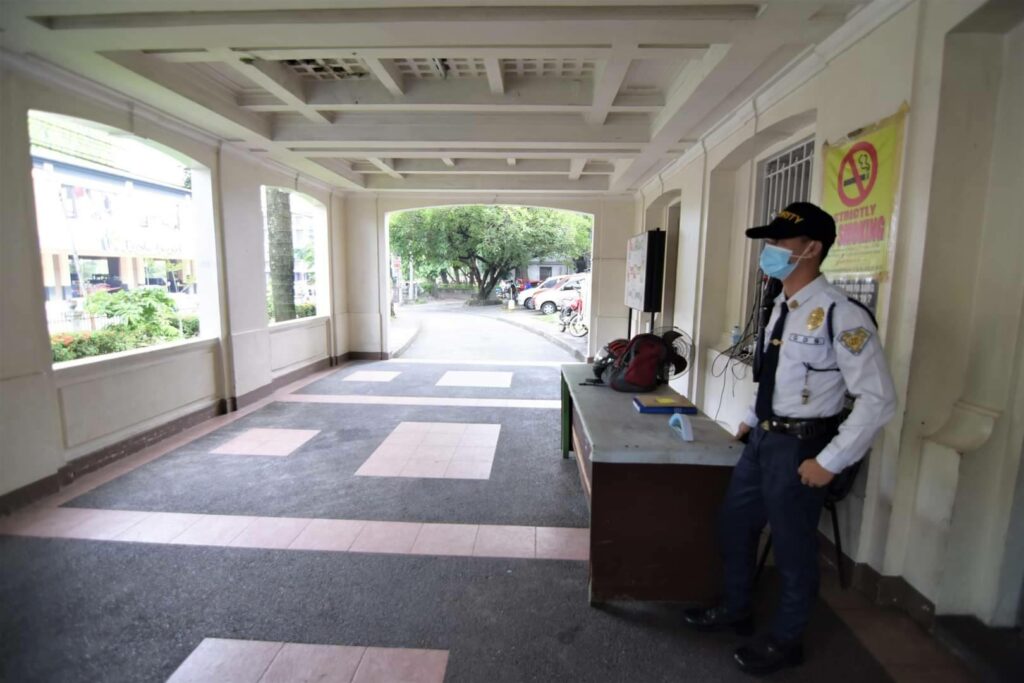 A security guard stands outside the western entrance of Capitol along Gatuslao Street. Same photo credits