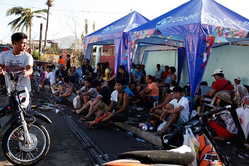 BUT FIRST THE MOBILE PHONES. Residents in Tacloban City line up to avail of free charging services being offered by a telephone company. This photo was taken a week after Yolanda left a trail of destruction in the country, killing at least 7,000 people. | Photo by Julius D. Mariveles