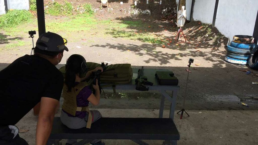BY THE NIR BAY 2 Former Army Capt. Jose Carlos Coruna watches over his daughter, Sysco, as she takes down steel targets at the NIR Gun Club in Bacolod City. Sysco is one of the students of Capt. Coruna in a unique defense system class he calls Downrange Daddy. | Screencap from video by Banjo C. Hinolan