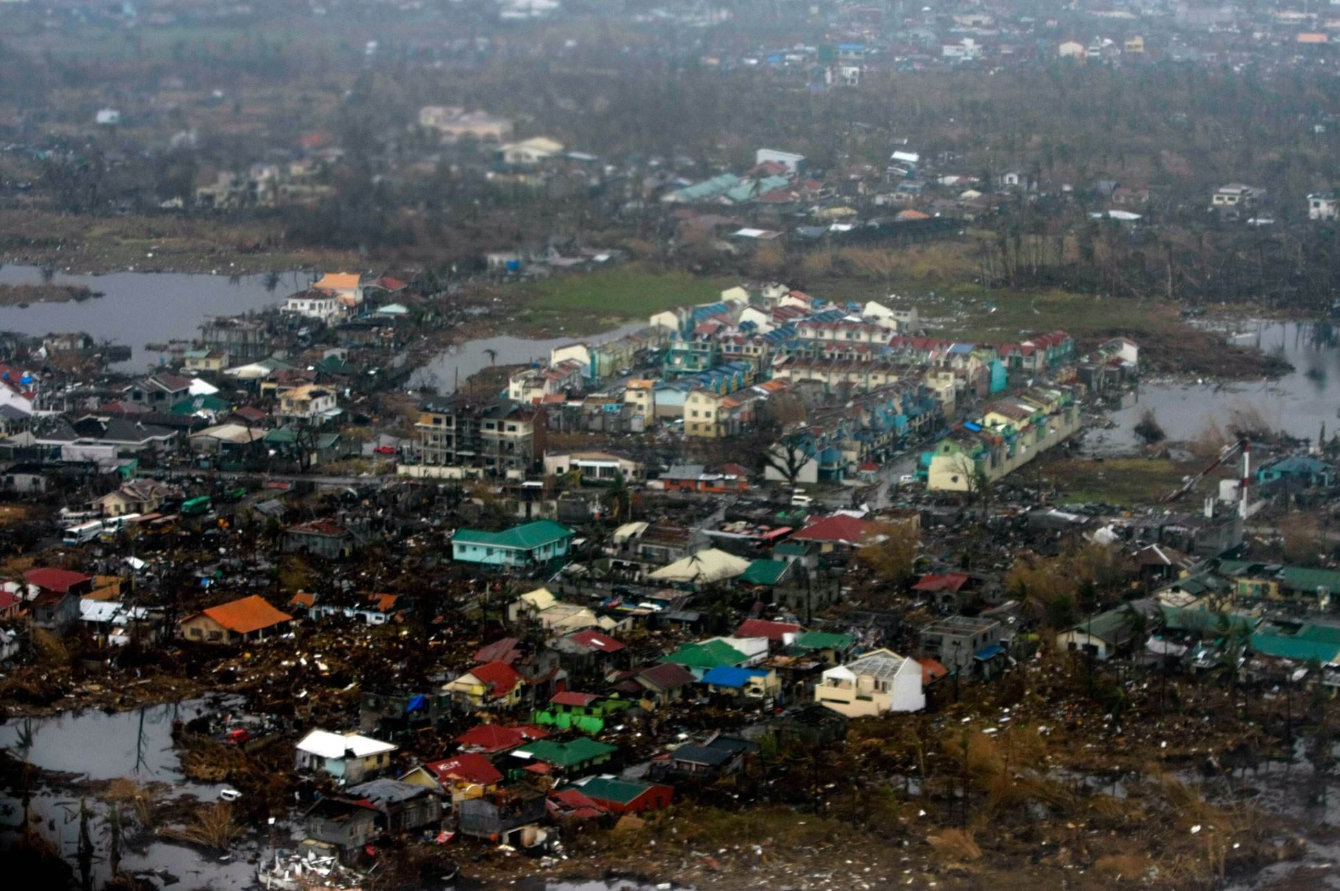 SPRAWLED, WOUNDED. Tacloban City, one of the hardest-hit areas by Typhoon Yolanda, from above a week after the superstorm struck, leaving thousands dead and a million displaced seven years ago. | Photo by Julius D. Mariveles
