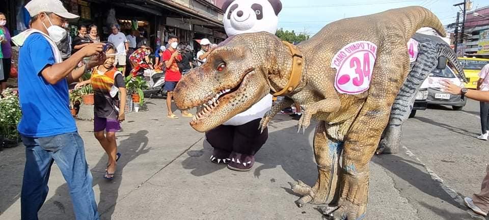 WITH A PANDA AND DINOSAUR. Businessman Ricardo "Cano" Tan turned heads today as he went around city streets in Bacolod with mascots representing a panda and a dinosaur on the start of the campaign period for local candidates. Tan is running as an independent candidate for councilor and owns the Campuestohan Highland Resort that features replicas of comic characters and larger-than-life dinosaurs.