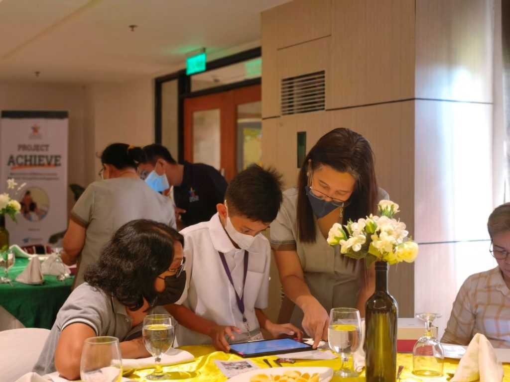 Children with Disabilities demonstrating to guests how to use the moodle app.